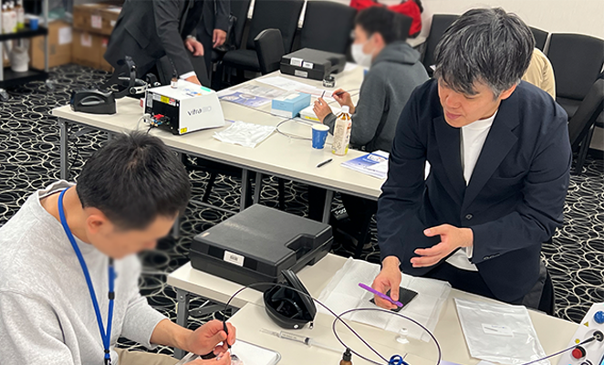 着席して豚眼にレーザーを当てている参加者に直接指導する仁藤先生