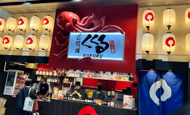 大阪のたこ焼き屋、「道頓堀くくる」の看板と店内カウンター