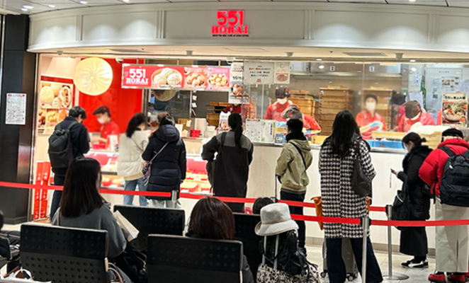 大阪の豚まんのお店、「551蓬莱」の看板とレジに並んでいる人々