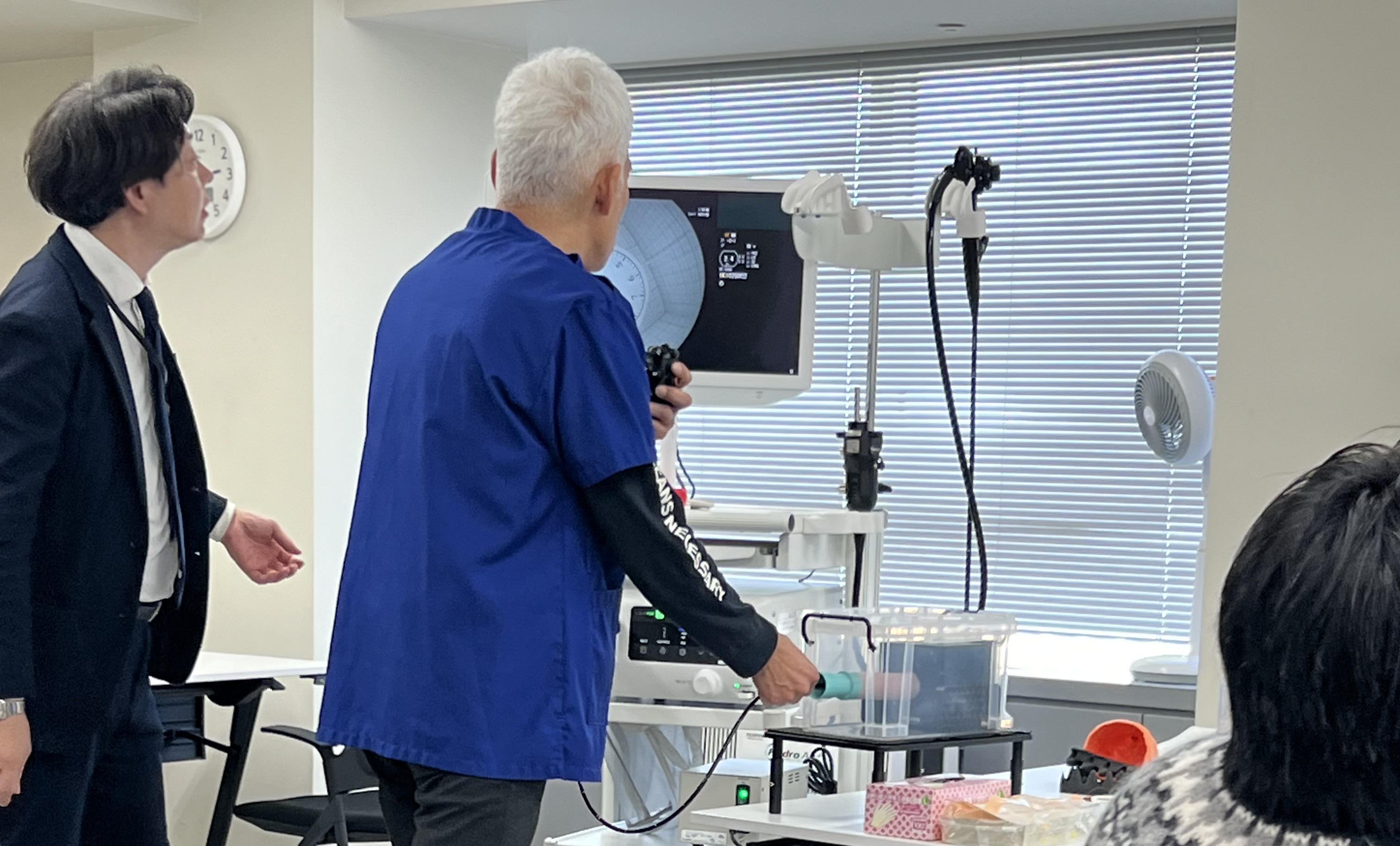 講師に教わりながら内視鏡を器具に挿入し、モニターに写された内部を観察する参加者